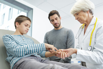 doctor examines child with a hand injury
