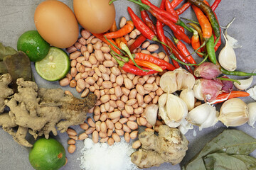a collection of spices, chilies, onions, nuts and various kinds on a concrete background