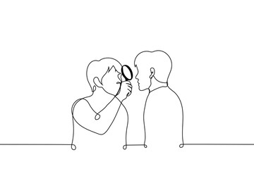 man looks at man through magnifying glass - one line drawing vector. concept a man studies another, alien too strange person