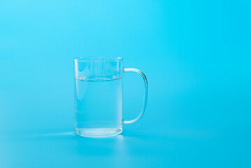A glass of water on blue background