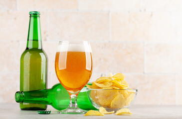 Beer glass, beer bottles and potato chips