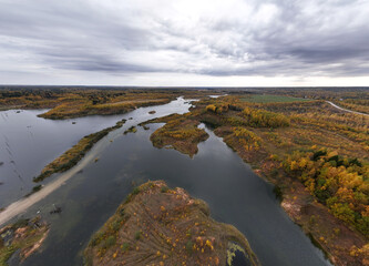 Fototapeta na wymiar panoramic view from a drone of a network of lakes and islands with a yellow forest against the backdrop of autumn colors