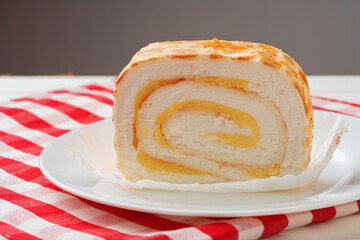 Meringue roll cake with cream on wooden table