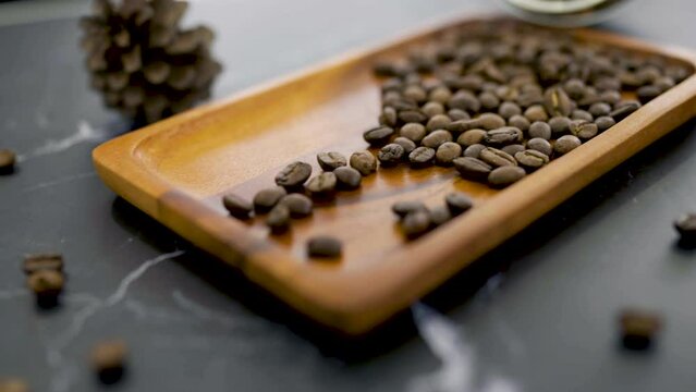 Close up roasted coffee beans on the wooden tray. Coffea excelsa, coffee beans seeds of coffee plant. Aromatic, Arabica drink bevarage.