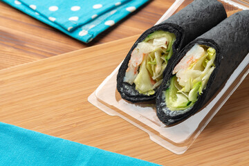 Tortilla wrap with shrimps and vegetables on wooden background