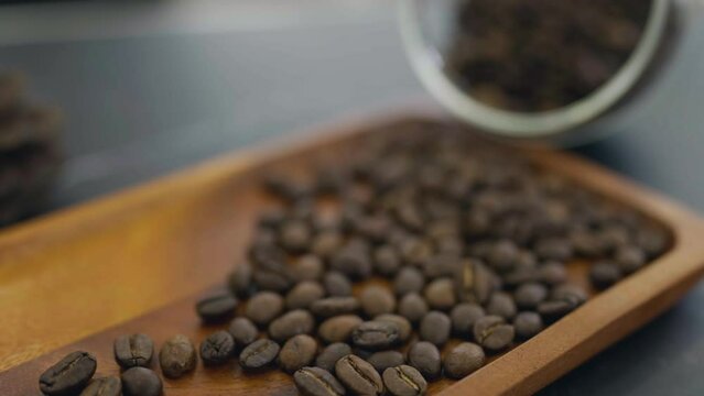 Close up roasted coffee beans on the wooden tray. Coffea excelsa, coffee beans seeds of coffee plant. Aromatic, Arabica drink bevarage.