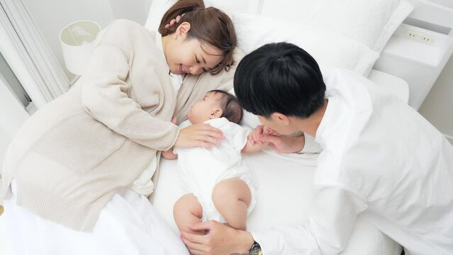 赤ちゃんを寝かしつける両親　子育てイメージ