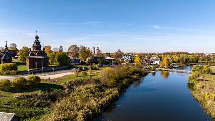 Naklejka premium panoramic view from a drone of ancient buildings and fields and forests against the backdrop of autumn colors in Suzdal