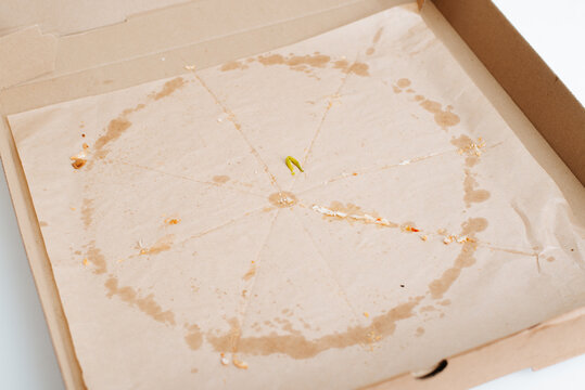 Food delivery, empty cardboard box with crumbs and traces of fat. Eaten pizza