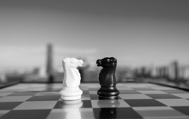 Two chess knights on city background © xy