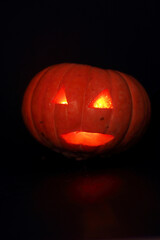 spooky concept - jack-o-lantern with burning eyes on dark background