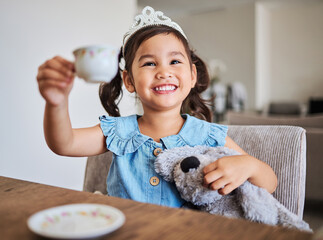 Tea party, happy girl and happiness of a young child on a home kitchen table with a smile. Play, fun and Asian kid from China with a tiara at a house smiling and playing with a cup and teddy bear - Powered by Adobe
