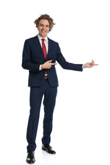 modern businessman with curly hair pointing fingers to side and smiling