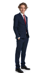 happy young businessman smiling and posing with hands in pockets