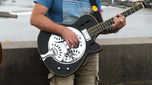 A Street Musician Playing A Resonator Guitar - close up