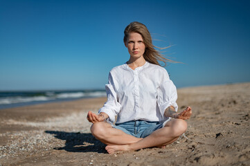 Fototapeta na wymiar Girl practice meditation on the beach. With space for text or design