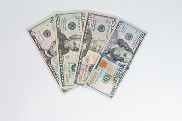 5, 20, 50, 100 dollars banknotes at different angles. Close up of dollars on white background.