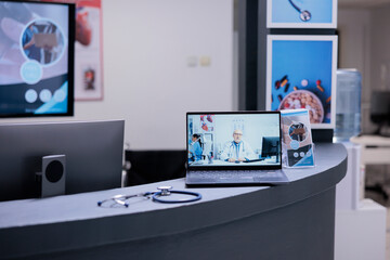 Doctor giving remote medical consultations from home by videoconferencing on computer. Telemedicine clinic attending patients through video calls with laptops connected to internet.