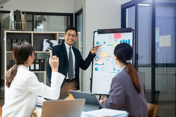 Fototapeta premium Group of Asian business meeting in planning design in creative business discussing work in the office.