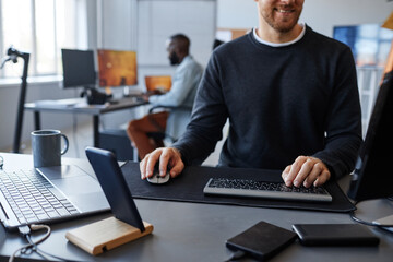 Cropped shot of male software developer at computer workstation, copy space