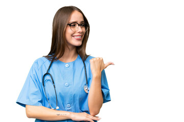 Young nurse caucasian woman over isolated background pointing to the side to present a product