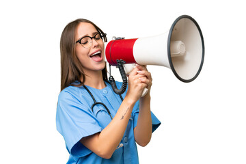 Young nurse caucasian woman over isolated background shouting through a megaphone
