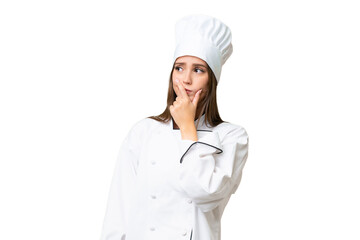 Young chef caucasian woman over isolated background having doubts and with confuse face expression