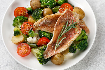 Sea fish with vegetable, perch with broccoli, cauliflower, tomatoes, potatoes on white plate....