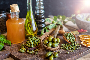 Capers in spoon and bowl on the table