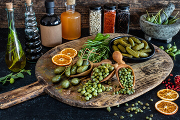 Capers in spoon and bowl on the table