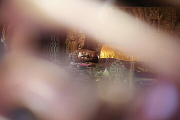 wooden buddha and blurred foreground.