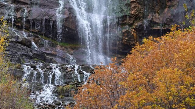 Bridal Veil Falls cascading down the rocks viewing colorful Fall leaves in Provo Canyon.