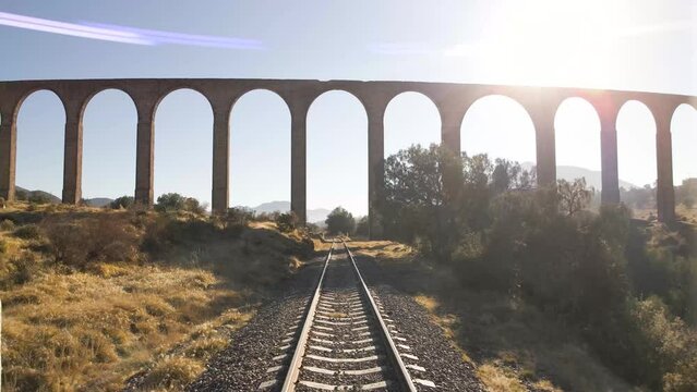 Beautiful tracking shot of UNESCO world heritage site Aqueduct of Padre Tembleque in Mexico captured at the time of sunset and revealing the railroad track and landscape