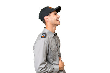 Young security man over isolated background laughing in lateral position