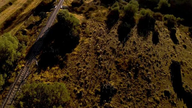 Cinematic aerial drone shot flying over railroad track later reveals and gets close to UNESCO world heritage site Aqueduct of Padre Tembleque in Mexico