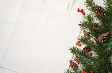   Mock-up eco friendly beige or white color  canvas cotton fabric tote bag with pine branch and cones. Christmas, New Year. Shopping sack mockup blank template. Reusable bag for groceries and shopping