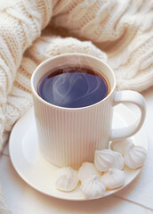 Winter, Christmas, New Year decorations composition, concept, background. White Mug, cup of tea, coffee, steam, meringue, knitted plaid. Christmas mood morning. Christmas greeting card.