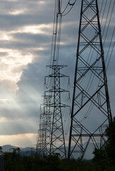 High voltage tower with power lines with Sunlight ray in the evening.