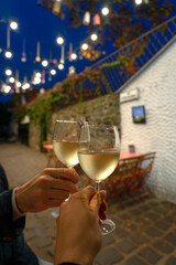 Couple drinking white wine in a restaurant on a romantic streeet with lights in Szentendre Hungary