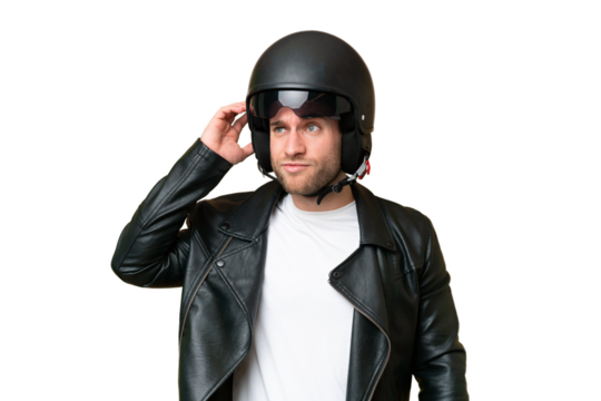 Young caucasian man with a motorcycle helmet isolated on green chroma background having doubts