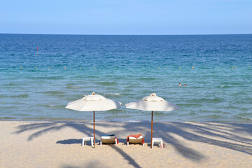 Tropical beach resort loungers and umbrellas under a blue sky in Koh Samui. Thailand