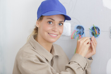 happy female electrician fixing electricity problem