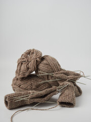 Brown socks hand made of sheep wool. Top view photo of knitted socks, needles and ball of warm...