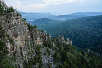 Mountain range rock wall against the background of hills, landscape mount Aigir Bashkortostan Russia, wildlife, morning in the mountains.