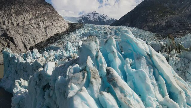 Flying close above the ice blocks of Dawes Glacier, Endicott Arm Fjord, Inside Passage, Alaska. Global warming. Aerial drone view