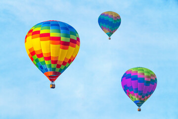 Naklejka premium Three hot air balloons on a blue sky