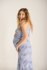 pregnant woman in a blue summer sundress, on a plain light background