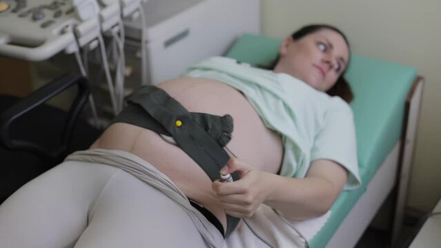 A pregnant woman undergoes a medical examination. Cardiotocography for an infant. A method of functional assessment of the state of the fetus during pregnancy and childbirth, which allows you to see