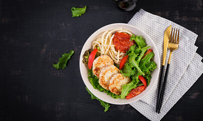 Spaghetti pasta, chicken burgers and salad in bowl. Chicken patties. Lunch. Top view, above, copy space