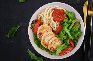 Spaghetti pasta, chicken burgers and salad in bowl. Chicken patties. Lunch. Top view, above, copy space